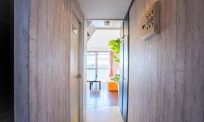 A hallway with wooden walls, a door, and a window.