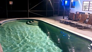 A swimming pool with clear water, surrounded by lounge chairs and a covered seating area. - Boca Raton Home with private heated pool, close to FAU, Beach & Mizner! (Boca Raton)