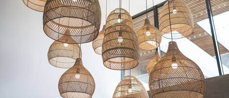 A series of hanging, woven pendant lights in a modern interior space.