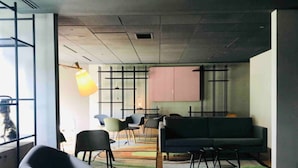 Un interior moderno con sofá, sillas, una mesa y un ventanal grande.