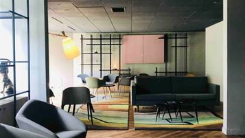 Ein modernes Interieur mit einer Couch, Sesseln, einem Tisch und einem großen Fenster.