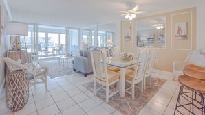Amplia sala de estar con mesa de comedor, sillas y un gran ventanal con vistas al exterior.