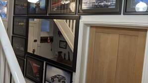 A staircase with framed automotive photographs on the walls. - Lovely Stables mew's house in hidden town location (Royal Tunbridge Wells)