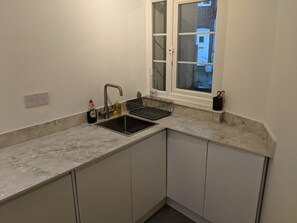 A small kitchen with a sink, a window, and a countertop.