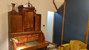 A room with a wooden desk, a yellow armchair, and a large cabinet. - Lovely Stables mew's house in hidden town location (Royal Tunbridge Wells)