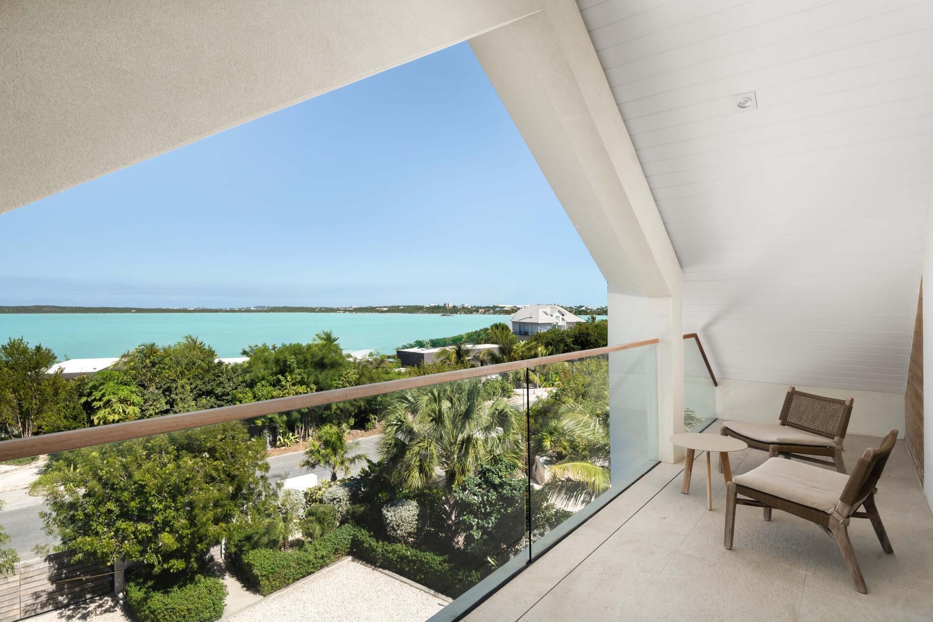A balcony with a view of the ocean and a distant island.