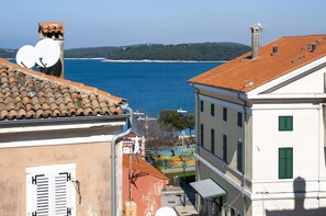 Experience the charm of a traditional coastal town with its terracotta-tiled rooftops and white-painted walls, set against a serene blue sea backdrop.