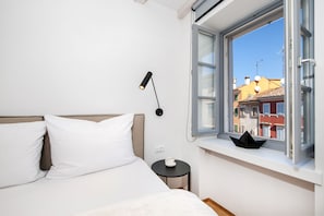 Enjoy a restful stay in this stylishly designed room with a comfortable bed, bedside table, and city view.