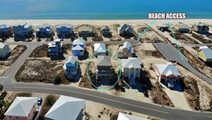 Zona residencial costera con casas y una carretera que conduce a la playa.