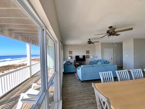 Relax in this spacious living area with a stunning beach view through large windows.