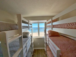 A bunk bed room with a view of the beach. - Beachfront and Updated! Pets OK! (Gulf Shores)