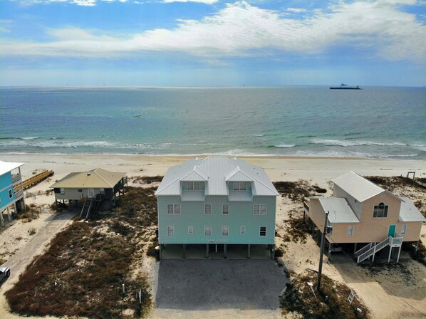 A beachfront property with a large house, a smaller building, and a dock. - Beachfront and Updated! Pets OK! (Gulf Shores)