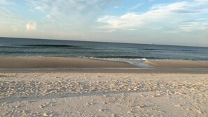 Una spiaggia con un litorale sabbioso e onde oceaniche.