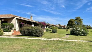 Una propiedad residencial con un césped cuidado, un camino que lleva a la entrada y un cielo azul despejado.