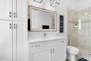 Een bad/douchecombinatie, een haardroger, handdoeken, toiletpapier