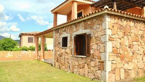 A stone house with a tiled roof and a covered patio. - Gli Asfodeli Four-room apartment sleeps 6 (San Teodoro)