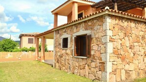 Una casa de piedra con techo de tejas y porche cubierto.