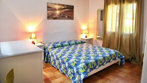 A bedroom with a bed, bedside lamps, a nightstand, a dresser, a painting on the wall, and a window with curtains.