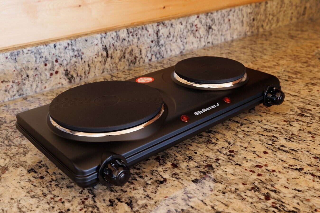 Työtasolla on musta elektroninen laite, mahdollisesti jokin keittiökone, ja siinä on tarra, jossa lukee ”EliteGourmet”.
