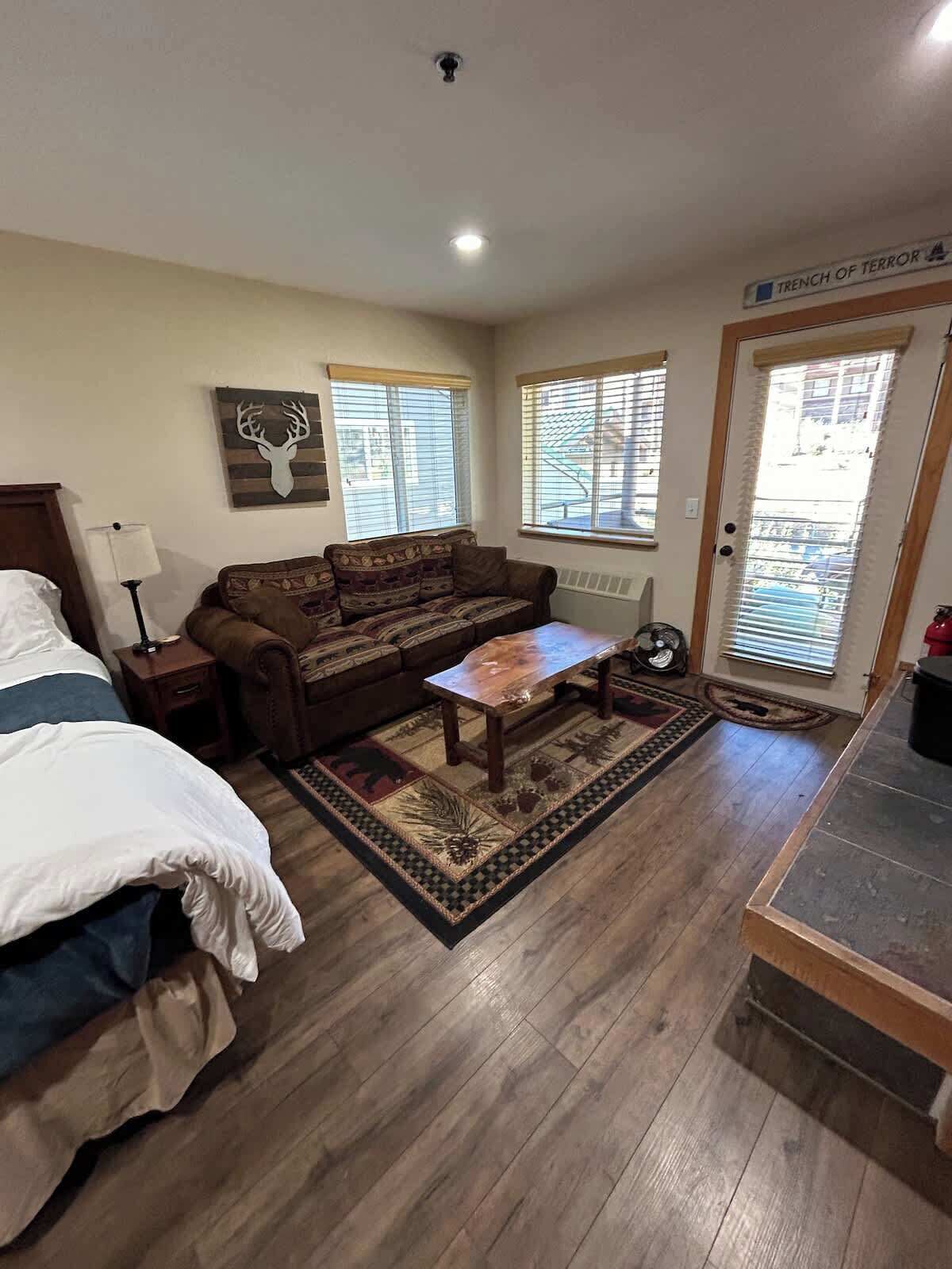 A room with a bed, a sofa, a coffee table, and a door labeled "Trench of Terror."