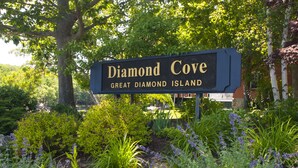Schild für 'Diamond Cove' mit üppigem Garten im Vordergrund.