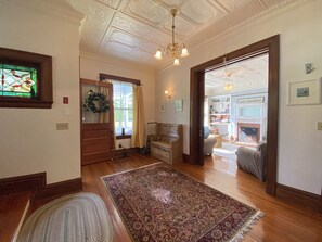 A spacious living room with a large rug, wooden flooring, and a fireplace. - Historic Officer's Quarters House on Great Diamond Island Near Beaches (Portland)