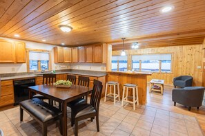 Un intérieur en bois comprenant une cuisine, un coin repas, un bar et un espace salon.