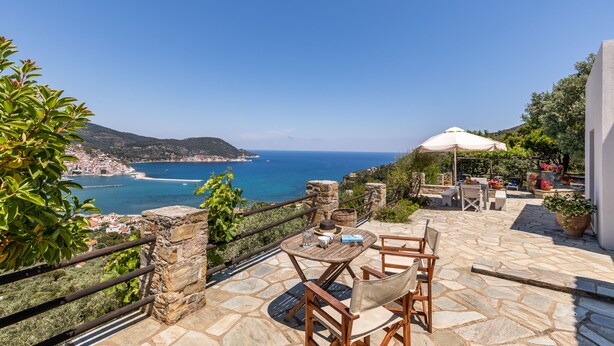 Un patio de piedra con mobiliario exterior con vistas al mar.