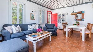 Un salón con sofá, mesa de centro y mesa de comedor.
