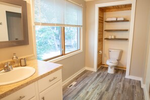 Een bad/douchecombinatie, een haardroger, handdoeken, zeep