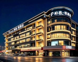 A multi-story hotel with a modern design, featuring balconies and a prominent signage for the hotel. - Paco Hotel Chebeinan Metro Guanghzou (Guangzhou)