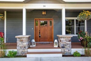 A house with a wooden front door, stone steps, and a number '14' above the door.