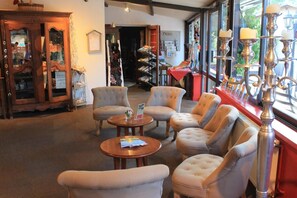 Un interior acogedor con sillones mullidos, un aparador de madera y una estantería.