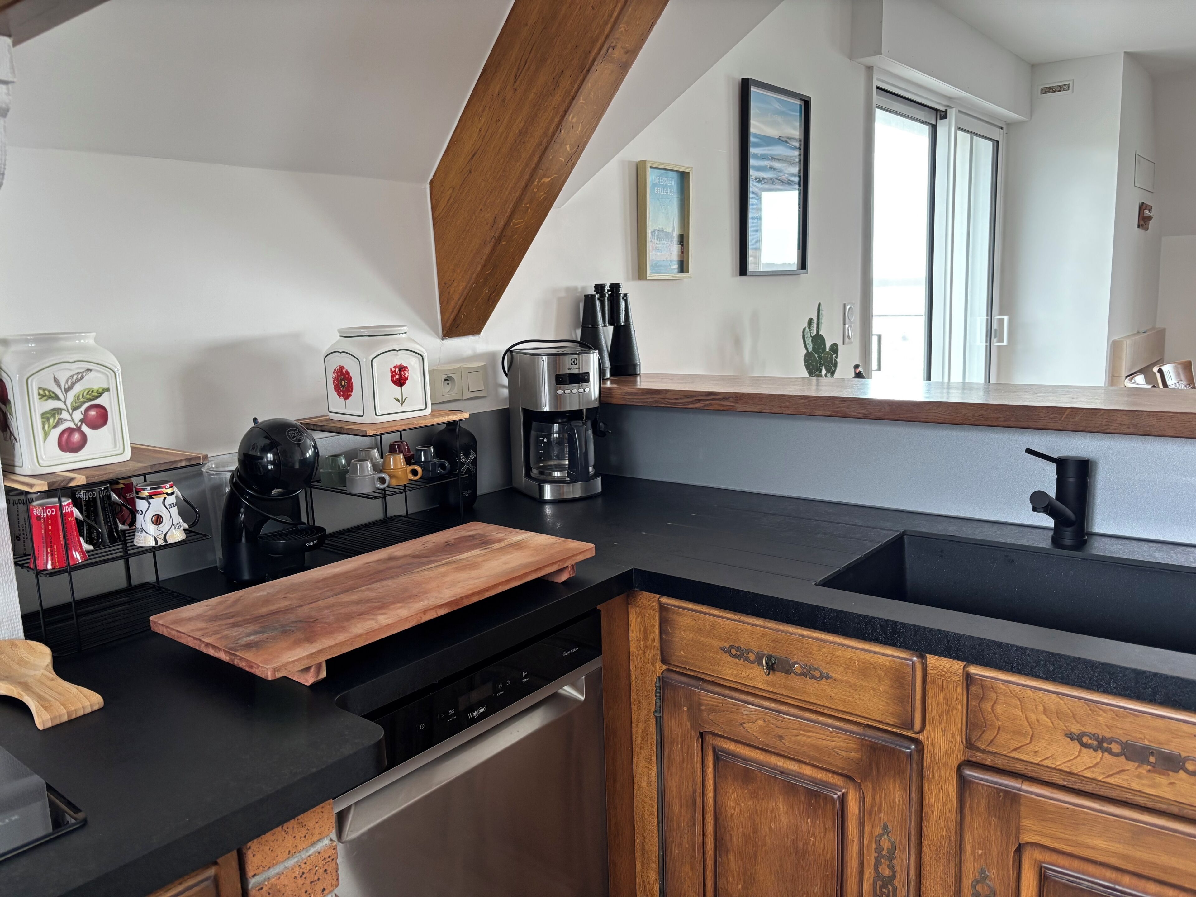 A modern kitchen with a built-in dishwasher, a coffee maker, and a wooden countertop.