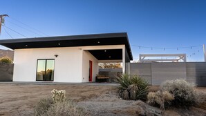 A modern house with a patio, a large window, and a door. - 15%DISCOUNT❤Hammocks❤Close 2 Downtown❤Fully Fenced (Joshua Tree)