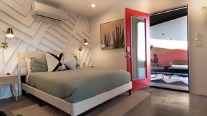 A modern bedroom with a bed, bedside tables, and a red door leading to a balcony. - 15%DISCOUNT❤Hammocks❤Close 2 Downtown❤Fully Fenced (Joshua Tree)