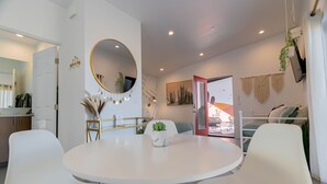 A modern living room with a round white table, white chairs, a round mirror, and a potted plant. - 15%DISCOUNT❤Hammocks❤Close 2 Downtown❤Fully Fenced (Joshua Tree)