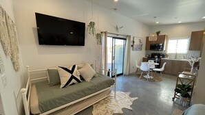 A modern, compact living space with a bed, a flat-screen TV, a kitchenette, and a dining area. - 15%DISCOUNT❤Hammocks❤Close 2 Downtown❤Fully Fenced (Joshua Tree)