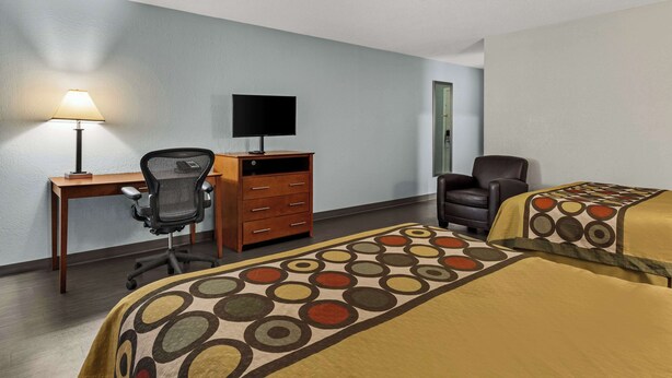 A hotel room with two beds, a desk with a computer, a chair, and a lamp. - Americas Best Value Inn Carlisle (Carlisle)
