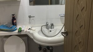 A bathroom with a white sink, a mirror, a toilet, and a shower. - One bedroom near Ansan Station (Ansanshi)