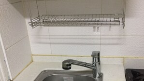 A kitchen with a stainless steel sink, a metal drying rack above it, and a stove to the right. - One bedroom near Ansan Station (Ansanshi)