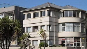Un immeuble à plusieurs étages, doté d’un toit plat, de grandes fenêtres et d’une enseigne sur laquelle on peut lire « Wavecrest ».