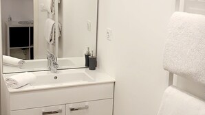 A modern bathroom with a white sink, mirror, and towel rack. - STUDIO hyper-centre/Lyon- Eurexpo/ Parc OL (Décines-Charpieu)