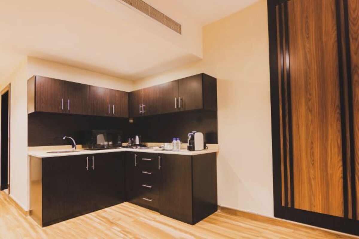 Una cocina moderna con gabinetes oscuros, una isla central y microondas integrado.