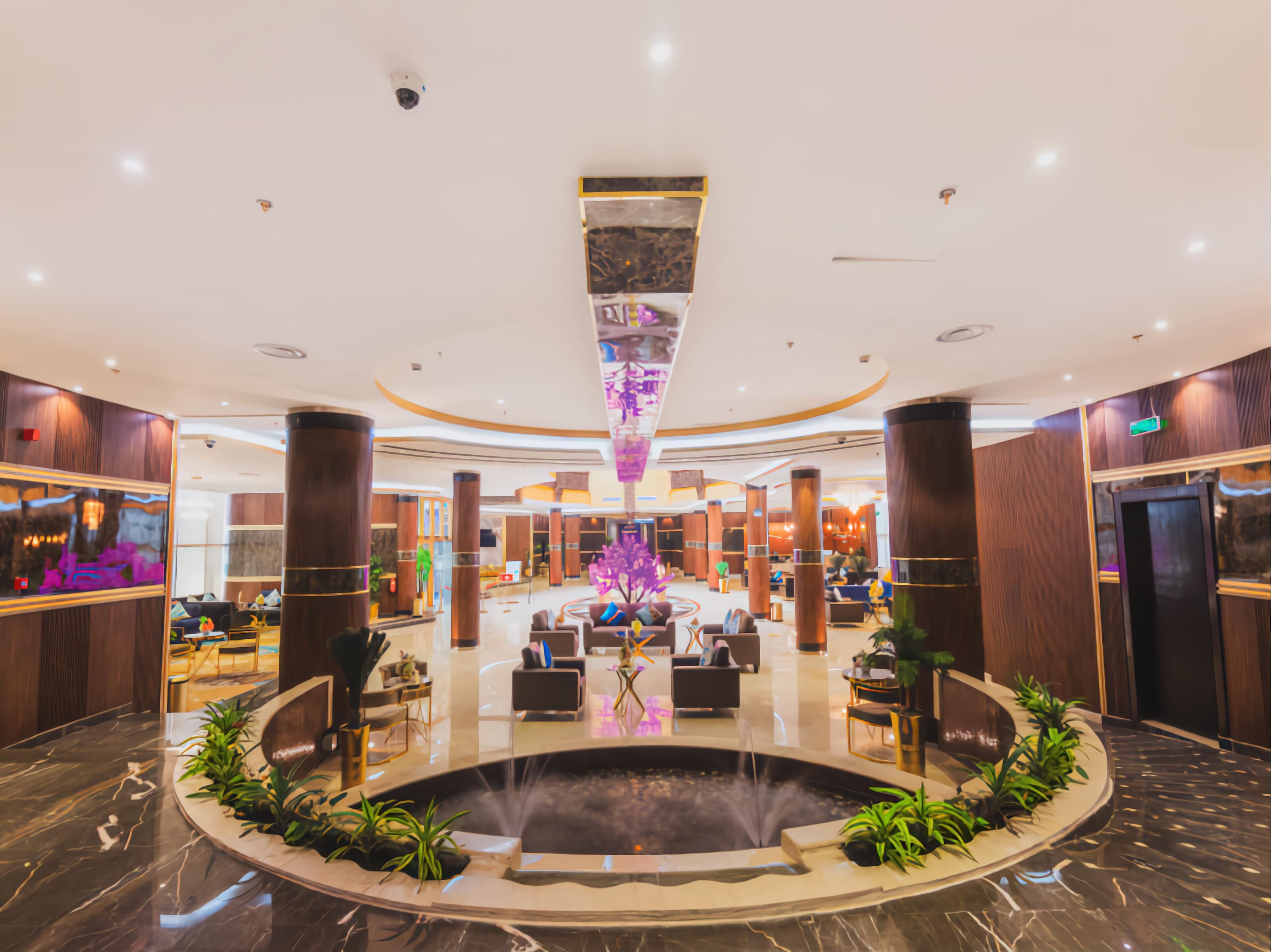 A spacious lobby with a central fountain, seating areas, and a modern design.