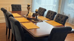 Une table à manger avec six chaises, des sets de table jaunes, des bougies et un centre de table décoratif.