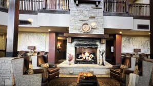 A spacious lobby with a stone fireplace, leather seating, and a balcony. - Beautiful Ski in and Ski out Lodge (Park City)