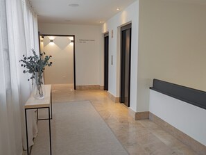 A hotel hallway with a reception desk, a vase with flowers, and a sign indicating room numbers 501-507. - Oriente (Zaragoza)