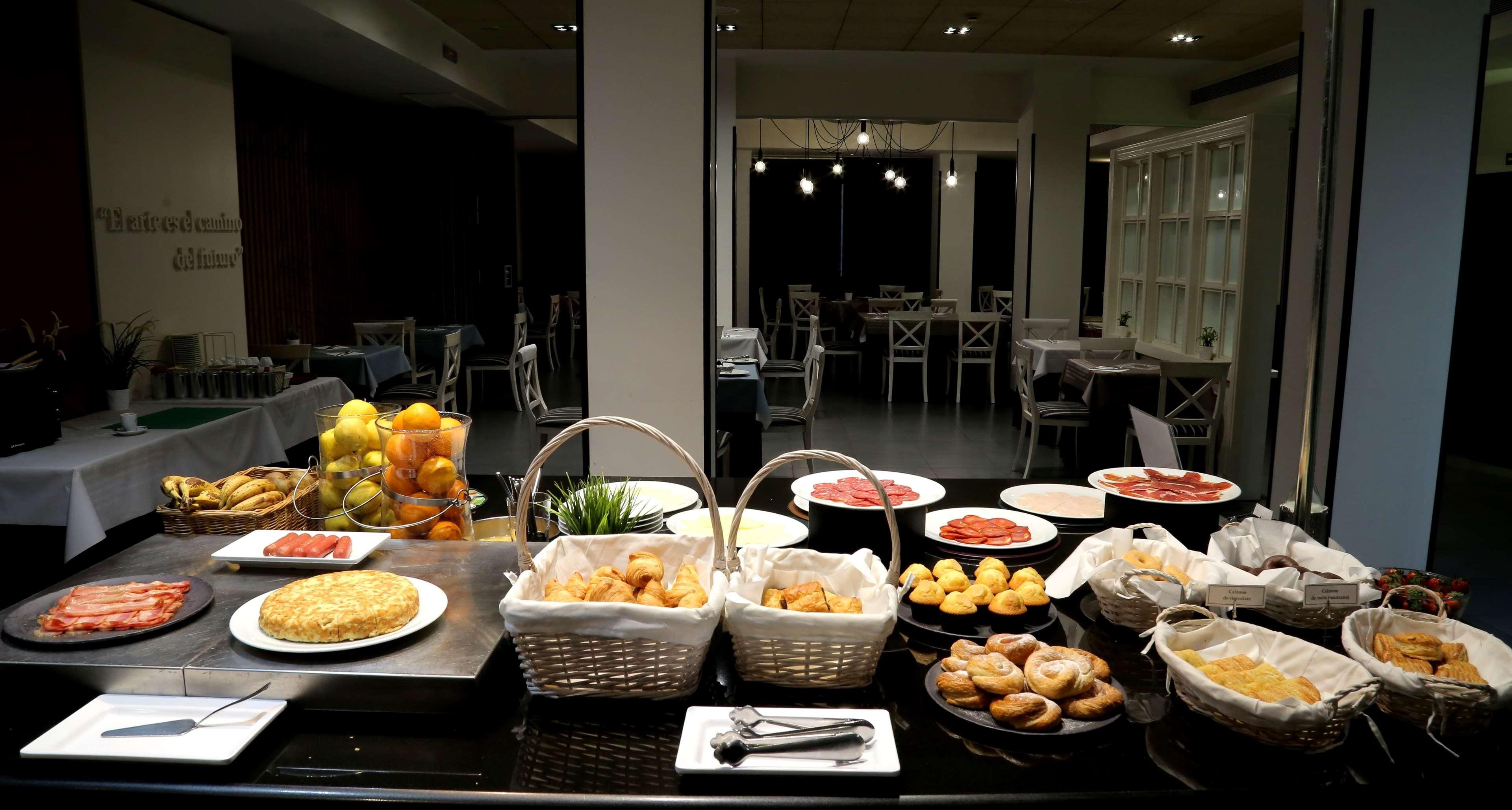 Monipuolinen buffet, jossa on tarjolla erilaisia ruokia ja leipäkoreja.