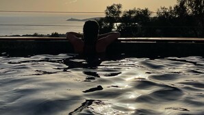 A person relaxing in a pool with a sunset view. - House (Cargèse)